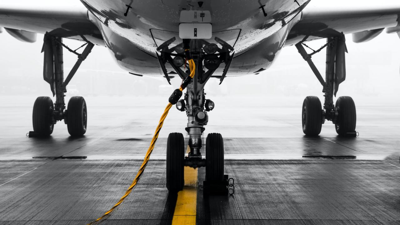 Airplane with yellow coated cable inserted near landing gear